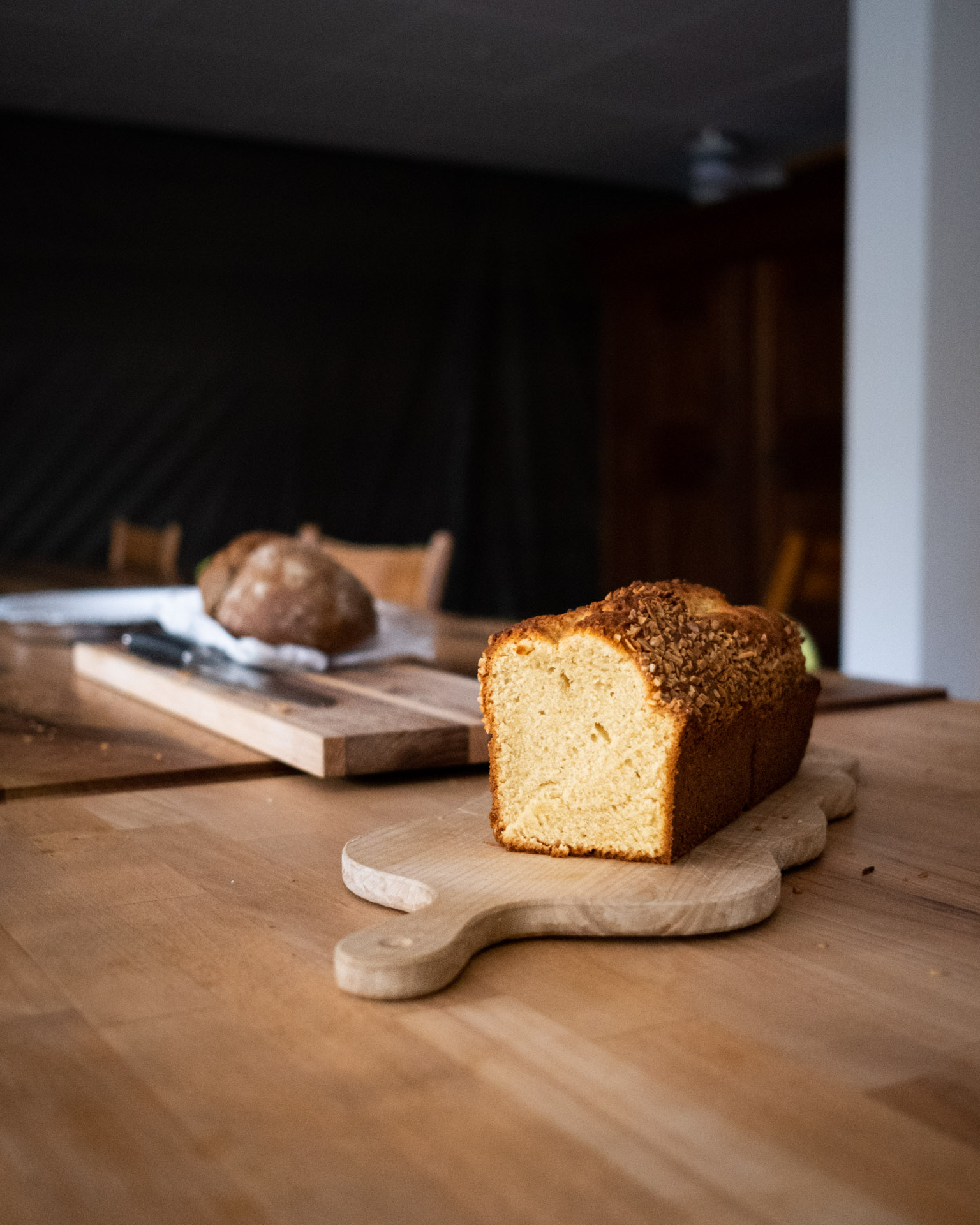 Ein frisch gebackener, aufgeschnittener Cake steht auf einem Holztisch.